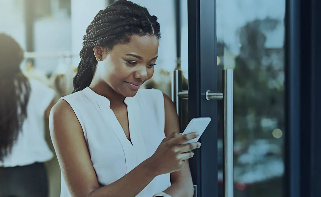 Mulher utilizando o celular para realizar o seu controle de ponto em nuvem